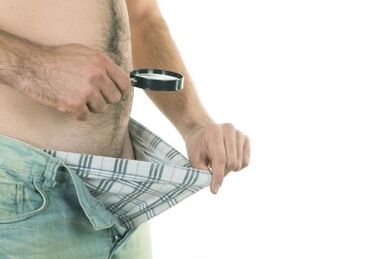 Vyras žiūri į savo penį, norėdamas padidinti jo dydį